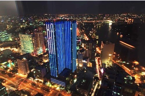 Outside looking and dynamic light system of the building create a brilliant light dance brightening the night sky of the city